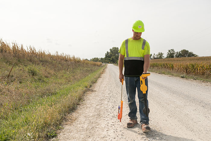 central cable worker marking cement with orange paint