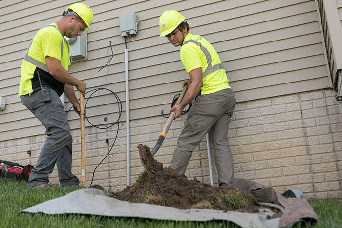 central cable worker placing cables at a home