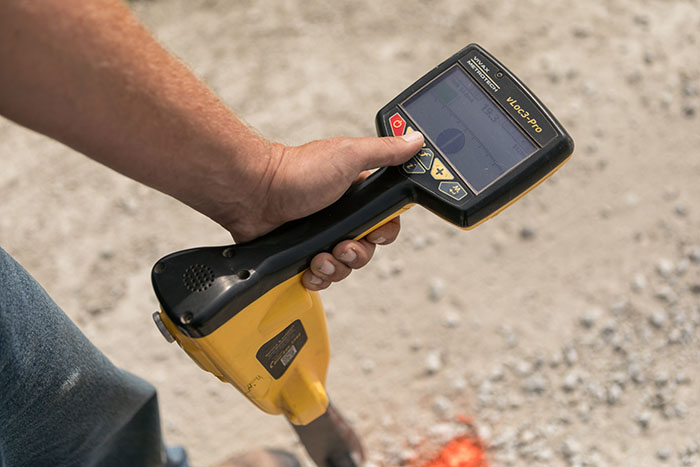 central cable worker marking cement with orange paint