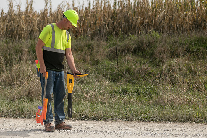 central cable worker marking cement with orange paint