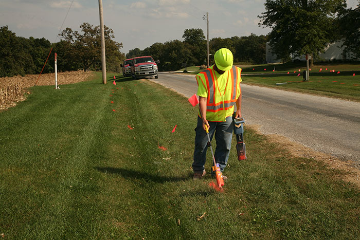 central cable worker marking grass with orange paint