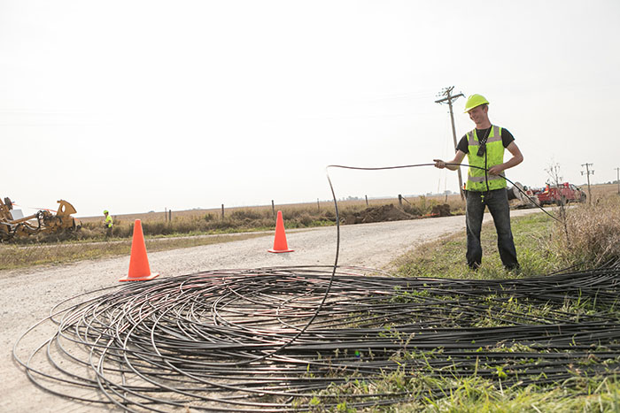 central table worker unrolling cables