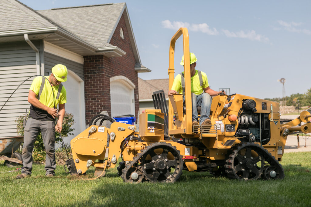 central cable workers putting wires underground at a home