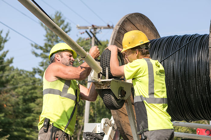 central cable workers unrolling a cable spool