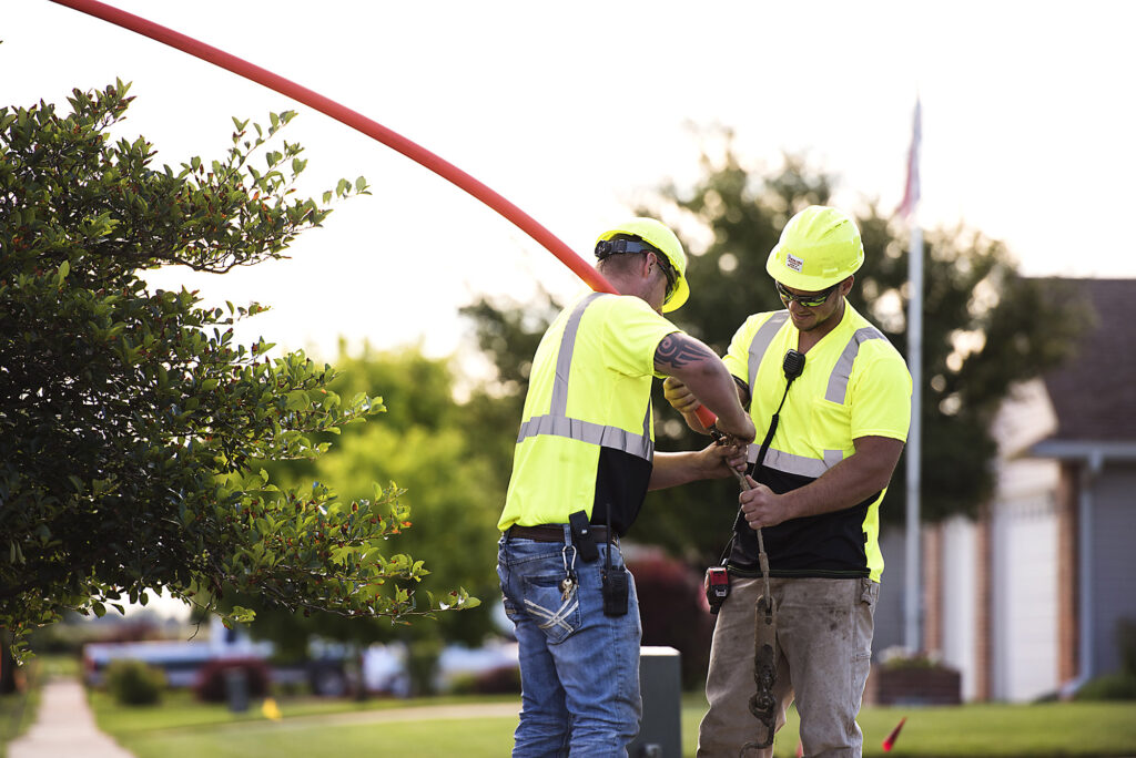 central cable workers fastening a cable tube to the ground