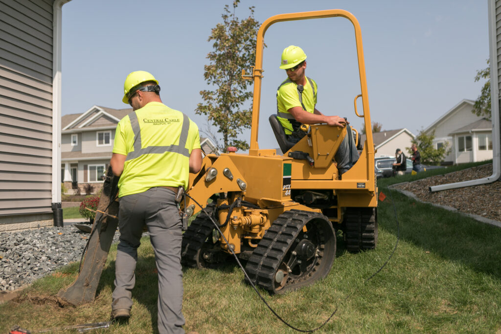 central cable workers placing wires at a home