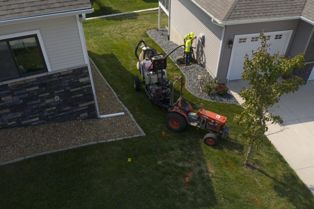 Central cable workers putting down cable at a home