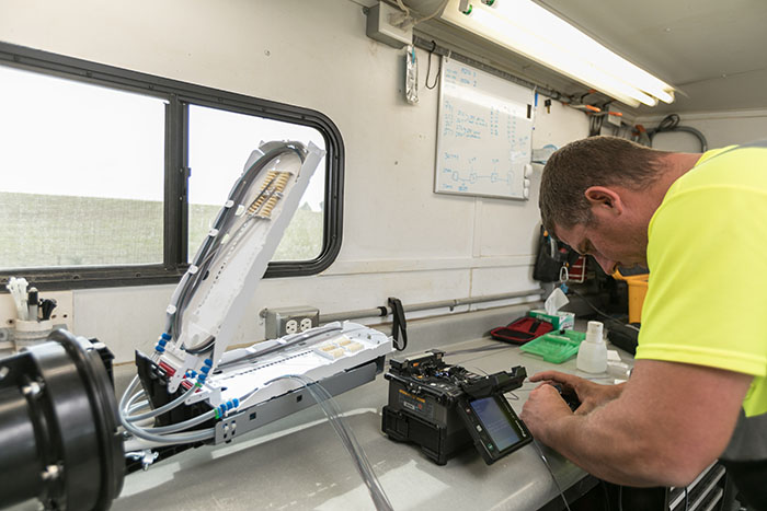 central cable worker looking at cable plates in a trailer